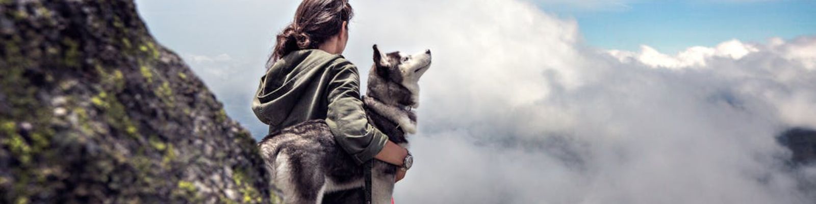 Mulher com cachorro em montanha